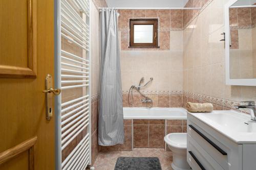a bathroom with a tub and a toilet and a sink at Apartman Noemi in Kukci