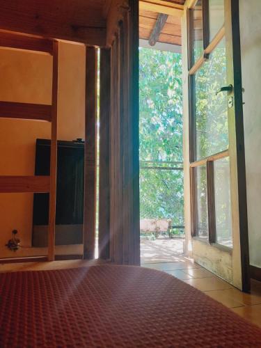 an open room with a large window and a bed at Arpegio Hostel in San Rafael