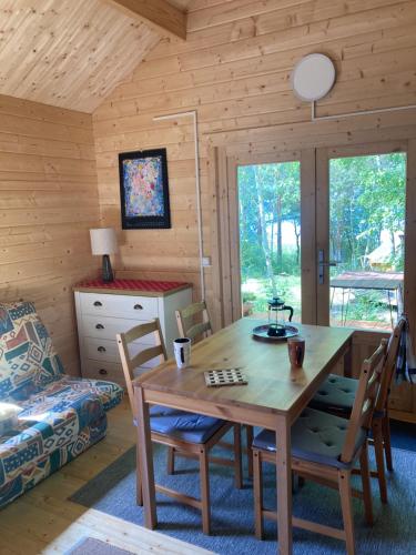 a dining room with a wooden table and chairs at Tiny House Seeblick in Casel