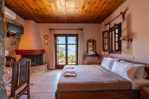 a bedroom with a large bed and a fireplace at Maistros Studios in Damouchari