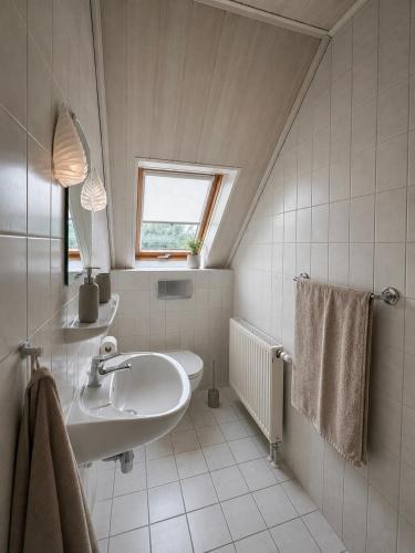 a white bathroom with a sink and a window at Pension Glück in Schleife