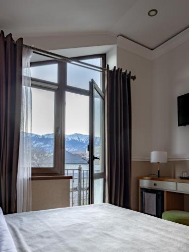 a bedroom with a large window with a mountain view at Mountain View Boutique Hotel in Almaty
