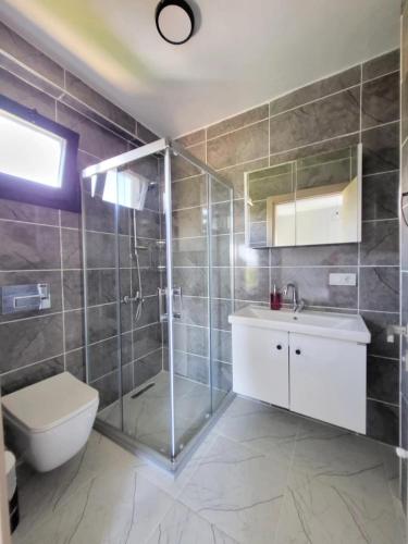 a bathroom with a shower and a toilet and a sink at Duplex Villa with Private Pool in Akyaka Ataköy in Muğla