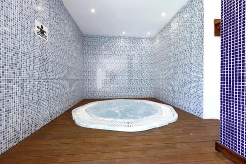 a bathroom with a hot tub in a room with white tiles at hotel apartamento es Talaial in Cala d´Or