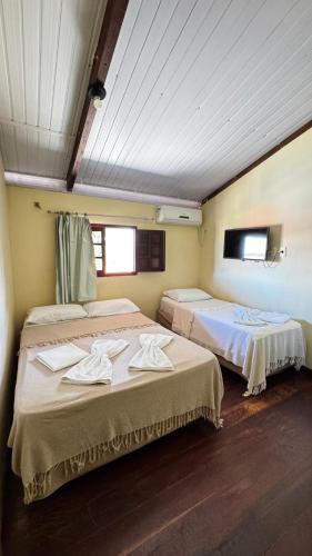 two beds in a room with two windows at Pousada Coco Verde Natal in Natal