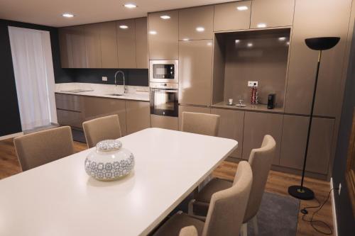 a kitchen with a white table and chairs in a room at Royal Galla Apartment in Macedo de Cavaleiros