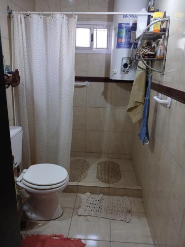 a bathroom with a shower curtain and a toilet at El Camino in Gardey