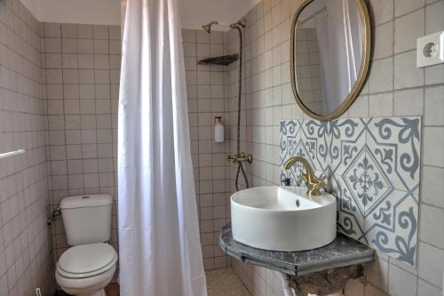 a bathroom with a sink and a toilet and a mirror at Monte Dos Avós in Mourão