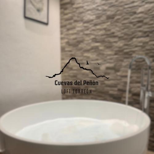 a white bath tub with a black graph on it at CUEVAS del PEÑÓN in Grazalema