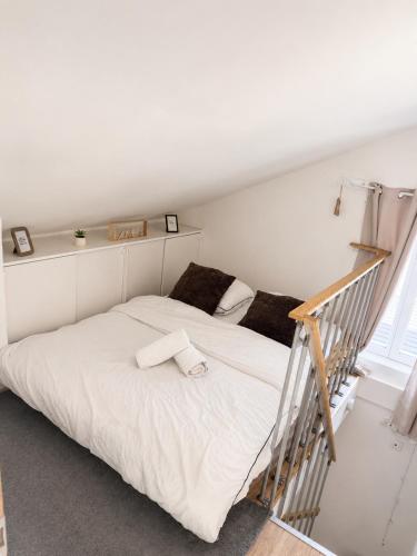a bedroom with a white bed and a staircase at Duplex with private outdoor spa close to Strasbourg city center in Strasbourg