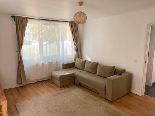 a living room with a couch and a window at Marc Apartament in Turda