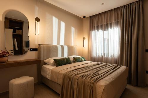 a bedroom with a bed with a mirror and a window at Capo Davia seaside Villa in Argassi