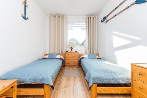 two twin beds in a room with a window at Jantar, dom blisko plaży z sauną in Jantar