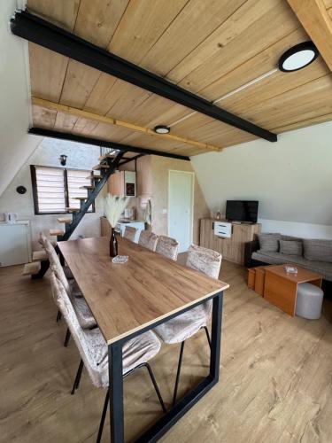 a dining room with a wooden table and chairs at Vikendica Vukasin in Zasavica Prva