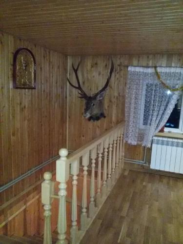 a room with a staircase with a deer head on the wall at Synevyrskyj Chardash in Synevyr
