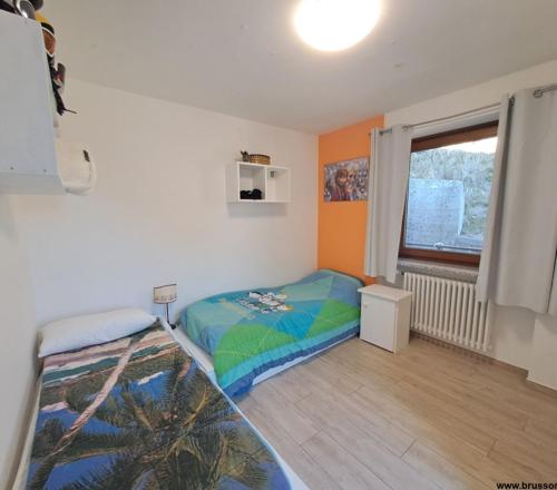 a small bedroom with a bed and a window at Villetta Col Ranzola in Brusson