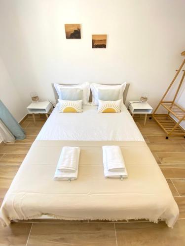 a large white bed in a room with two tables at Casa do Sol in Sagres