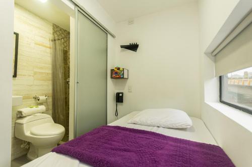 a small bathroom with a bed and a toilet at Hotel Zona Express San Diego in Medellín