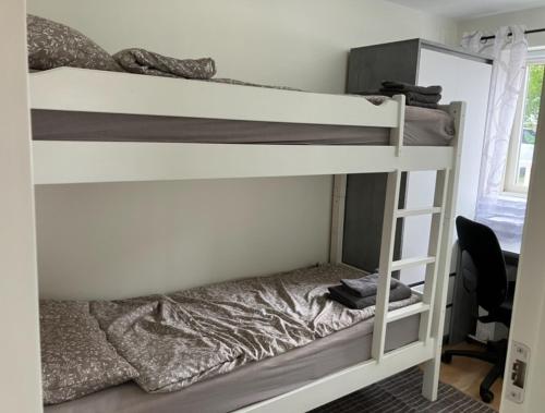 a bedroom with two bunk beds and a desk at Ferieleilighet Kragerø in Kragerø