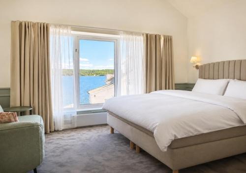 a bedroom with a large bed and a large window at Vilma Sjøbad in Filtvet