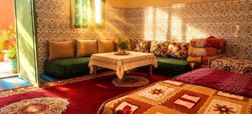 a living room with a couch and a table at Chambre partagée Hostel DAIFLAH in Oulad Rguia