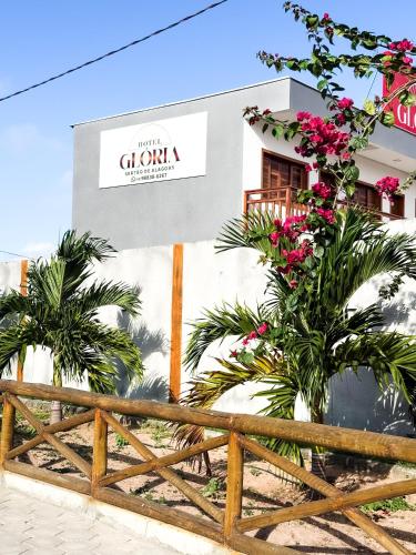 a building with palm trees in front of a fence at Hotel Glória in Piranhas