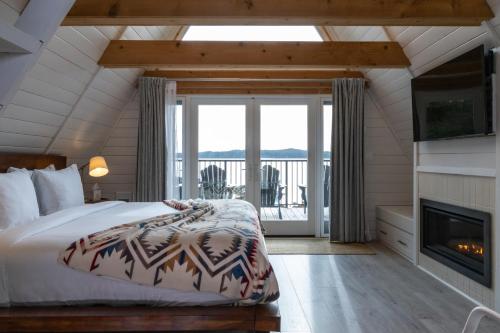 a bedroom with a large bed and a fireplace at Duffin Cove Resort in Tofino