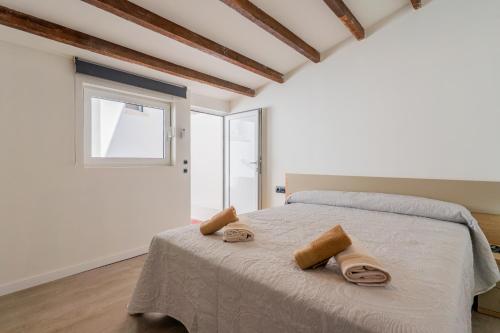 a bedroom with a bed with two towels on it at Elcano Living 6 in Grao de Castellón