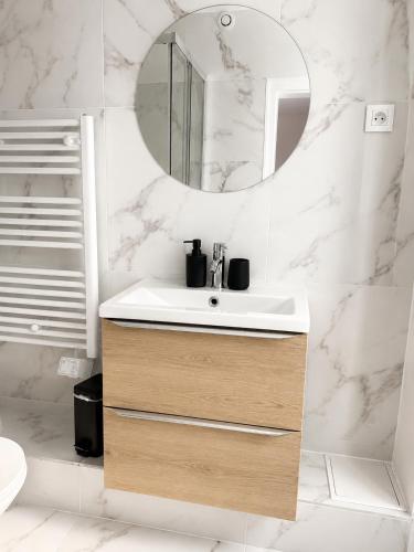 a bathroom with a sink and a mirror at Le Thuillat Limoges in Limoges