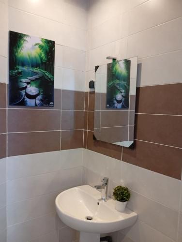 a bathroom with a sink and a picture on the wall at Résidence Prestige KGV Appt 301 in Douala
