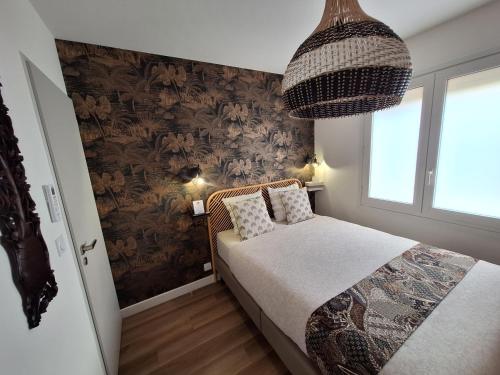 a small bedroom with a bed and a chandelier at Villa Pesona in Vias