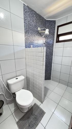 a white bathroom with a toilet and a shower at Pousada Coco Verde Natal in Natal
