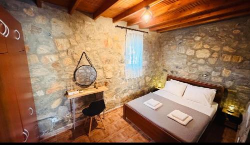 a bedroom with a bed and a desk with a mirror at campo villa in Mesimvría