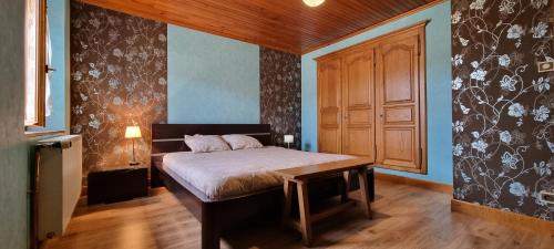 a bedroom with a bed and a wooden door at Le gîte des Sorbiers in Charmes-lès-Langres