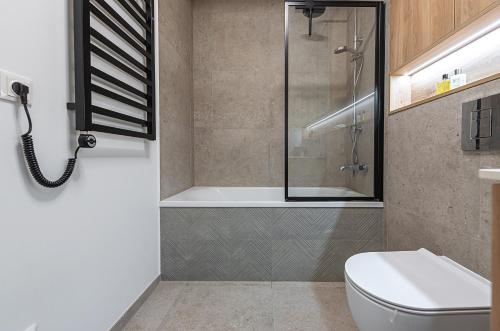 a bathroom with a shower and a toilet at V39 New Apartment in Vilnius