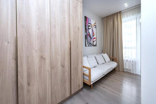 a white couch in a room with a wooden partition at V39 New Apartment in Vilnius