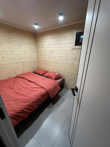 a small bedroom with a red bed in it at Green Village in Balqash