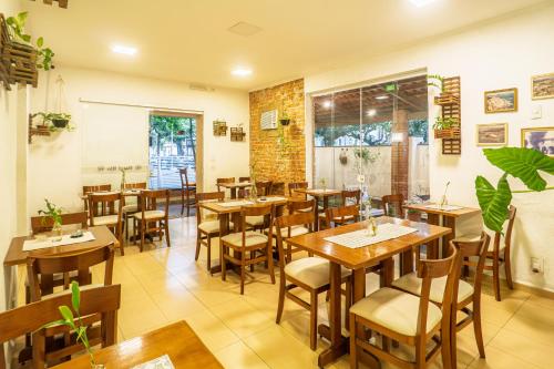 a restaurant with tables and chairs in a room at Hotel Rio Guarujá - "Sua casa na praia" in Guarujá
