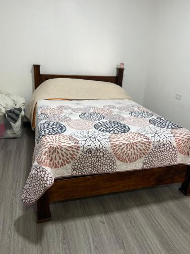 a bed with a comforter on it in a bedroom at El Encanto Alajuela in Alajuela