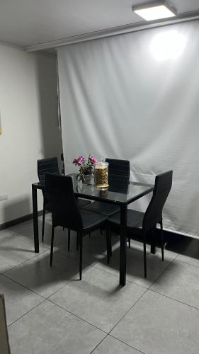a dining room table with chairs and flowers on it at El Encanto Alajuela in Alajuela