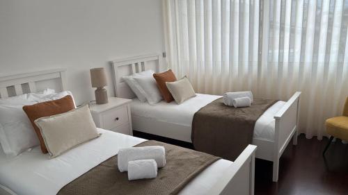 a hotel room with two beds and a chair at Beach House - Aguda Beach - 2 bedrooms in Arcozelo
