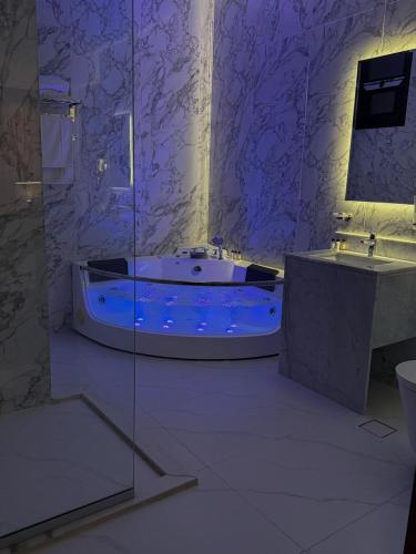 a purple bathroom with a tub and a sink at نارس البخاري in Buraydah