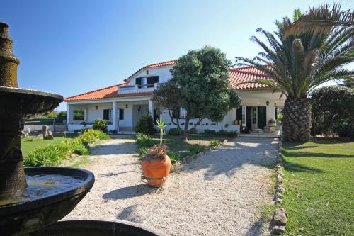 a house with a palm tree in front of it at Quinta Beira-Mar in Sintra