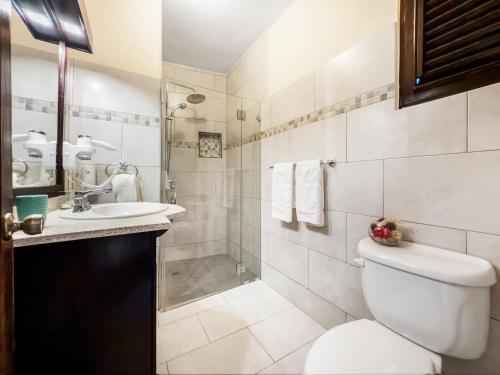 a bathroom with a toilet and a sink and a shower at Cabarete Palm Beach Condos in Cabarete