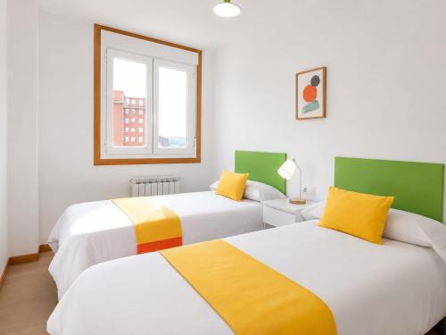 two beds in a room with green and white at Delta in Monforte de Lemos