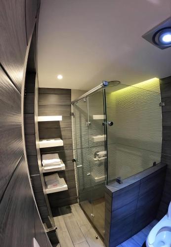 a bathroom with a glass shower and a toilet at Hotel Arizona in Mexico City