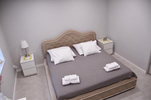 a bedroom with a bed with two pillows on it at Lemon & Jacuzzi in Boguszów-Gorce