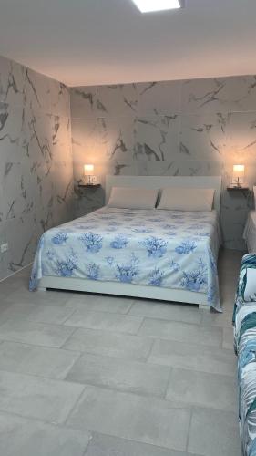 a bedroom with a bed with blue and white sheets at Camera in centro storico in Olbia