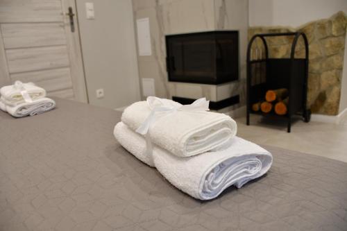 a pile of towels sitting on top of a bed at Lemon & Jacuzzi in Boguszów-Gorce