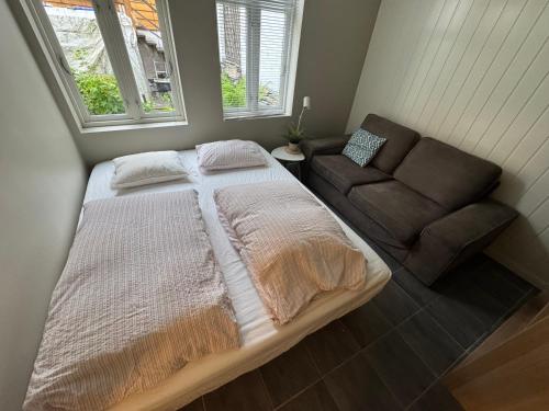 a bedroom with a large bed and a couch at Bergen City hostel Rooms in Bergen